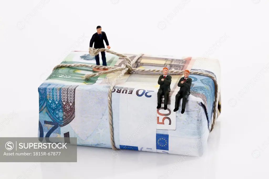 Managers figurines on package of euro notes