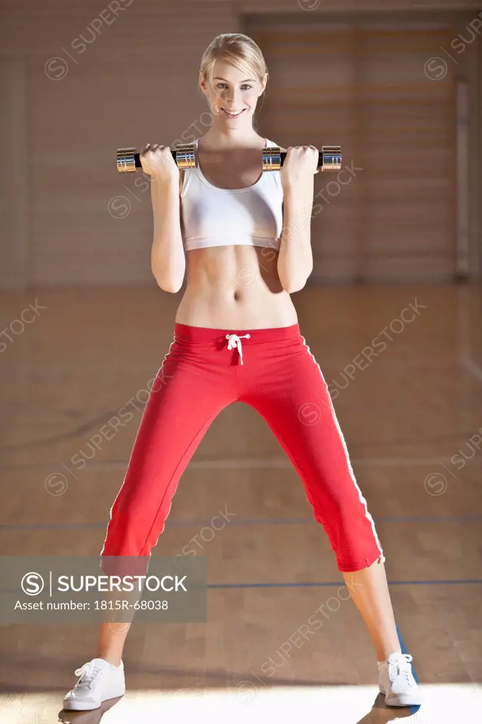 Germany, Mauern, Woman lifting weights, smiling, portrait