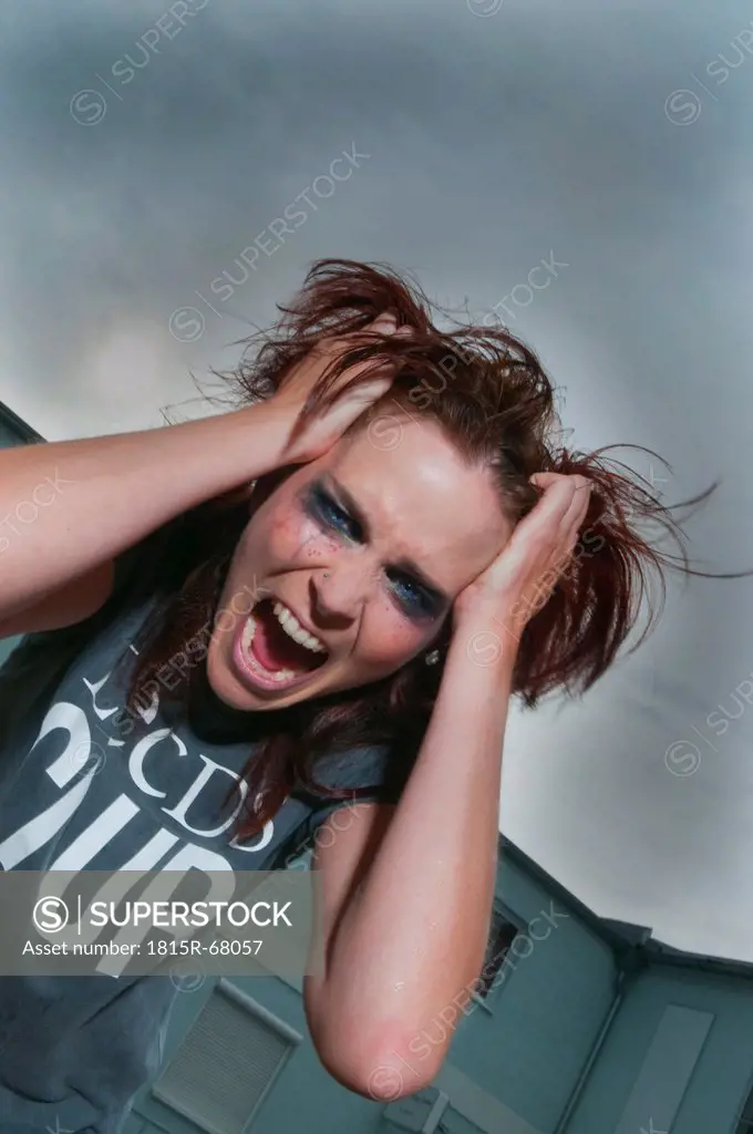Woman pulling her hair and looking angry.