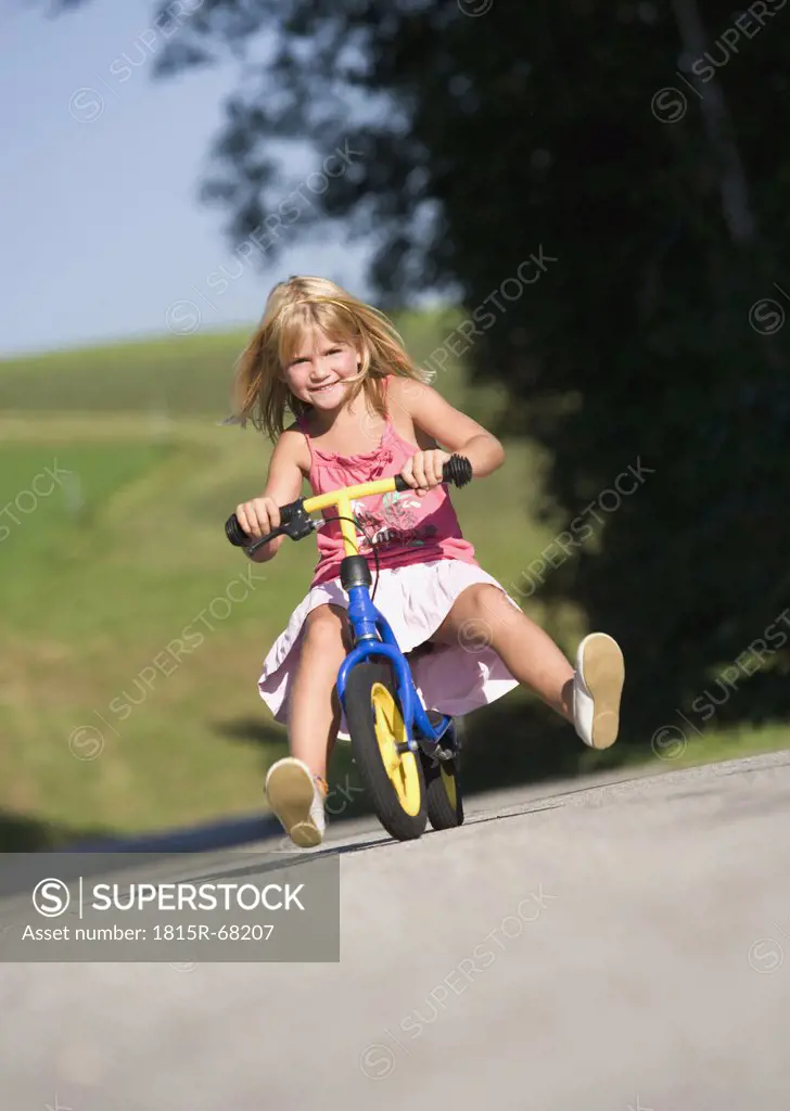 Austria, Mondsee, Girl 4_5 riding bicycle, smiling, portrait