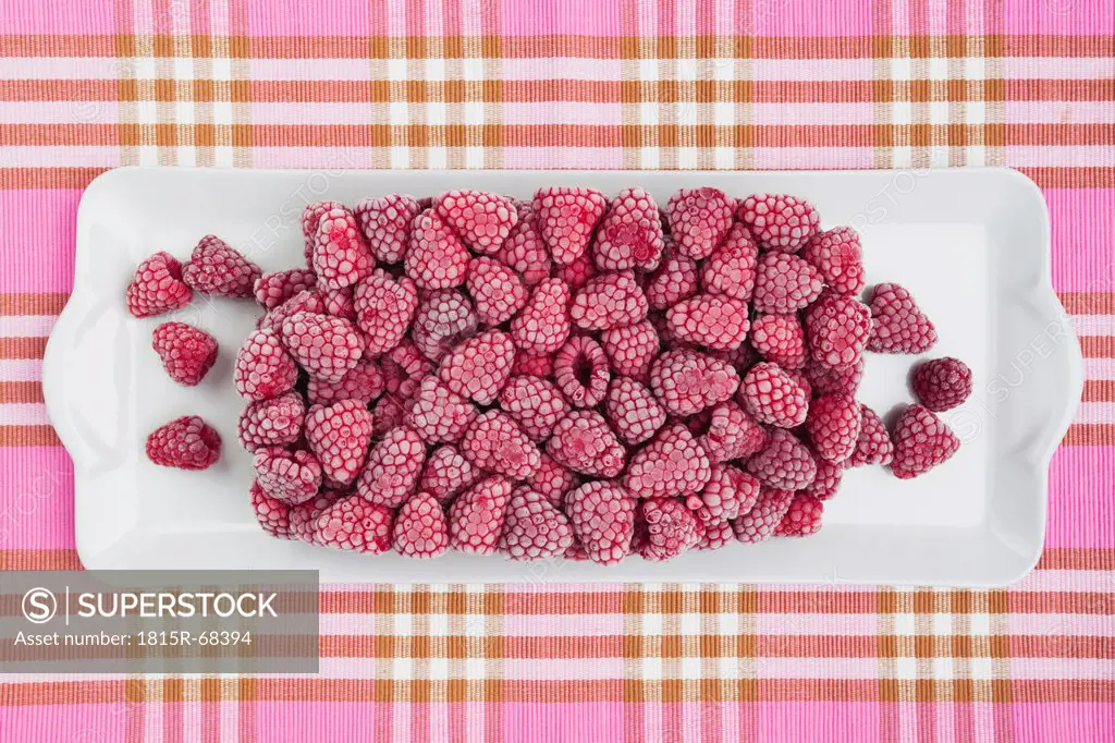 Frozen raspberry in tray on tablecloth