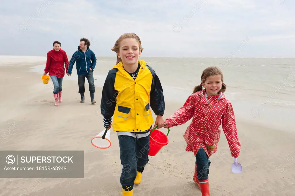 Germany, St. Peter_Ording, North Sea, Children 6_9 with parents walking on beach