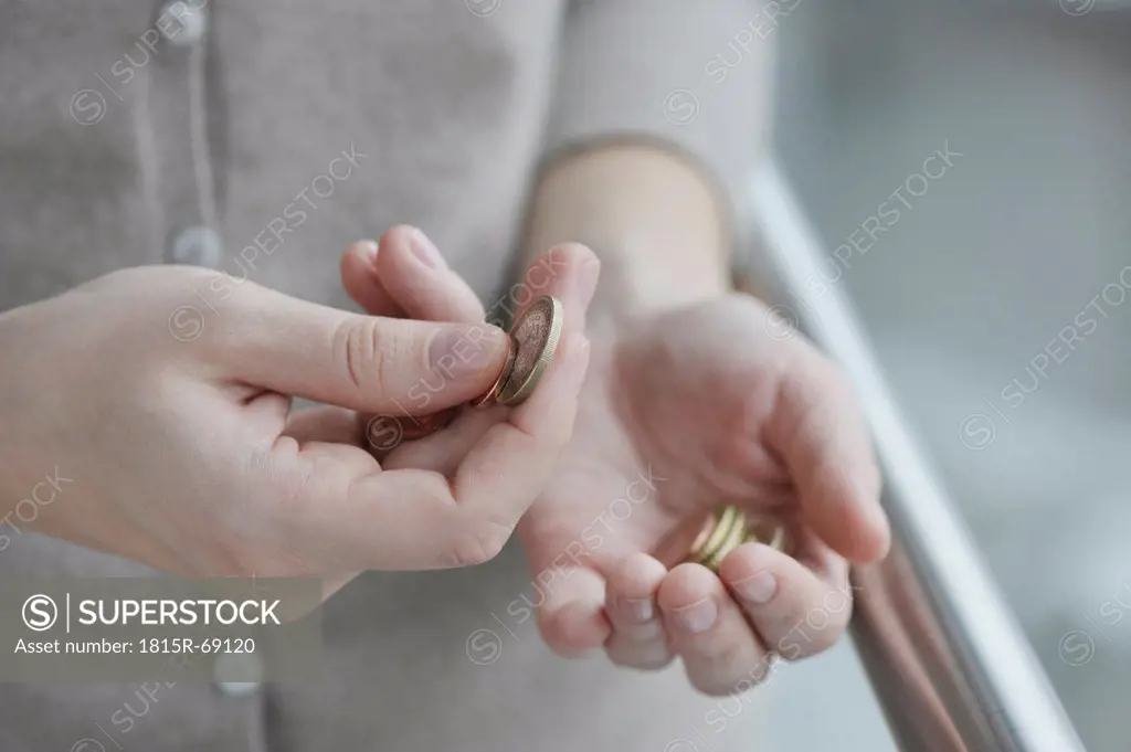 Woman counting euro coins, close up.