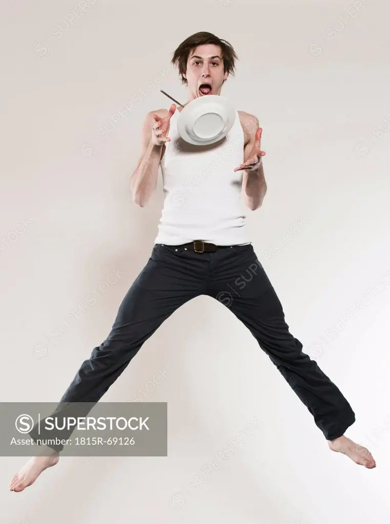 Man holding plate and jumping, portrait