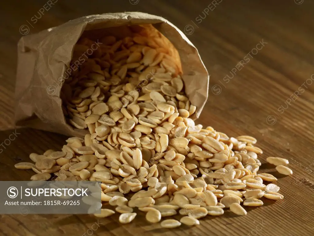Roasted soja seeds spilling on wooden surface