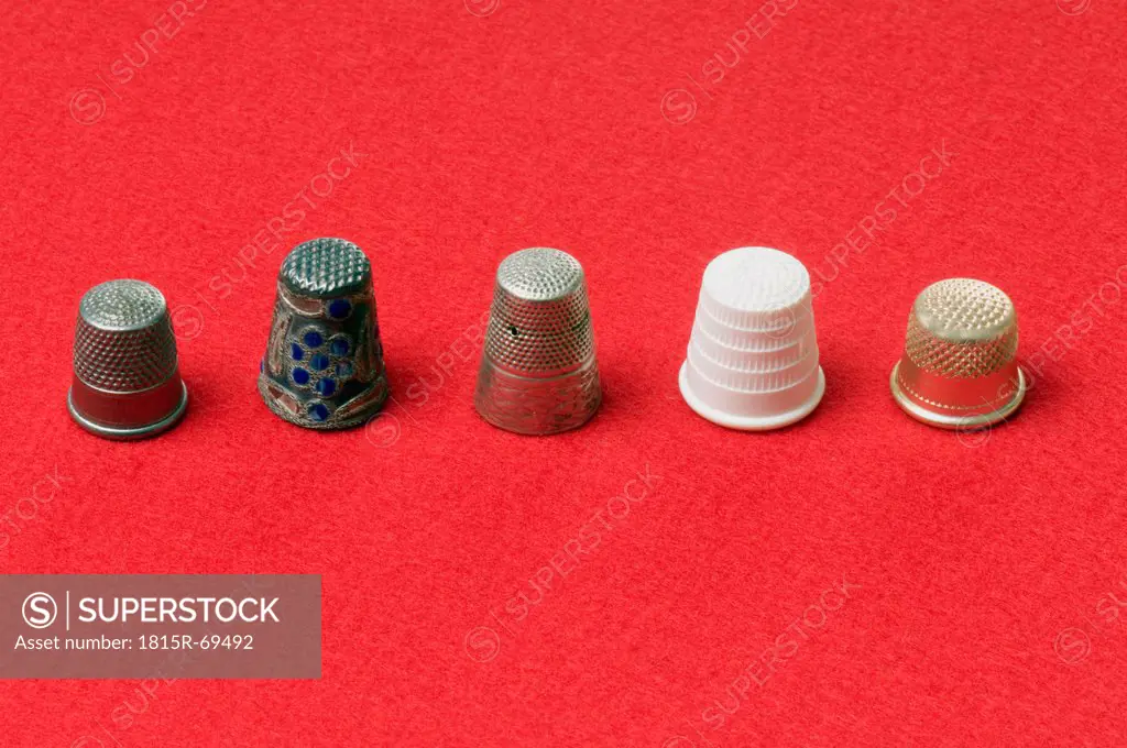 Variety of thimbles on red background