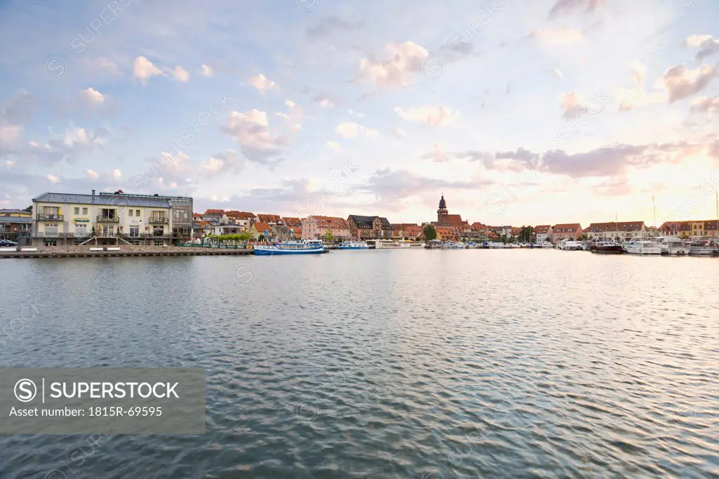 Germany, Mecklenburg_Western Pomerania, Waren, View of harbour with city at dusk