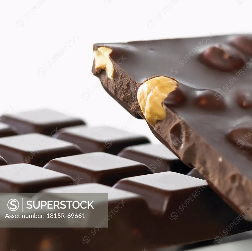 Chocolate with whole hazelnuts on white background