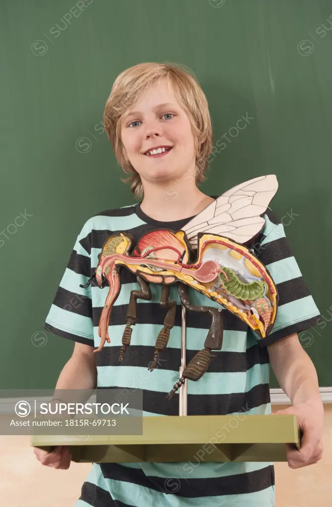 Germany, Emmering, Boy12_13 holding and fly model, smiling, portrait