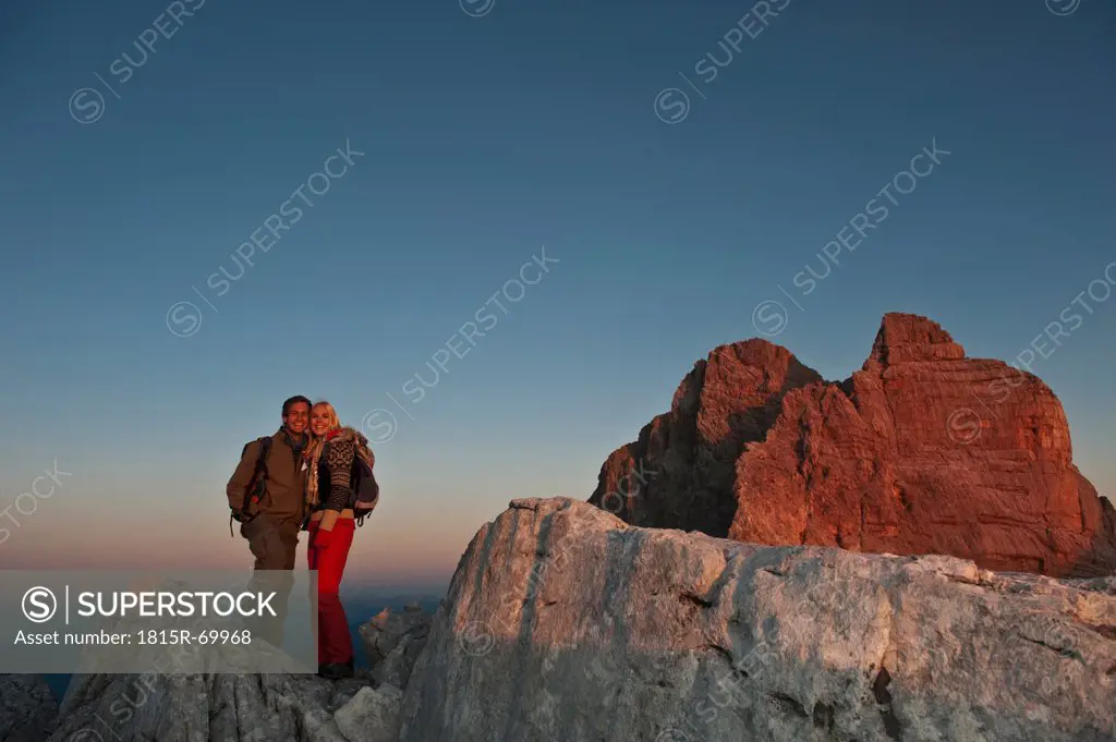 Austria, Steiermark, Dachstein, Couple hiking on mountain, standing on rock