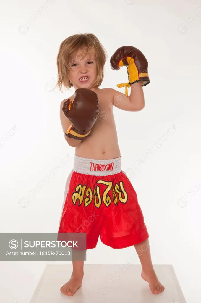 Boy 4_5 wearing boxing glove, clenching teeth