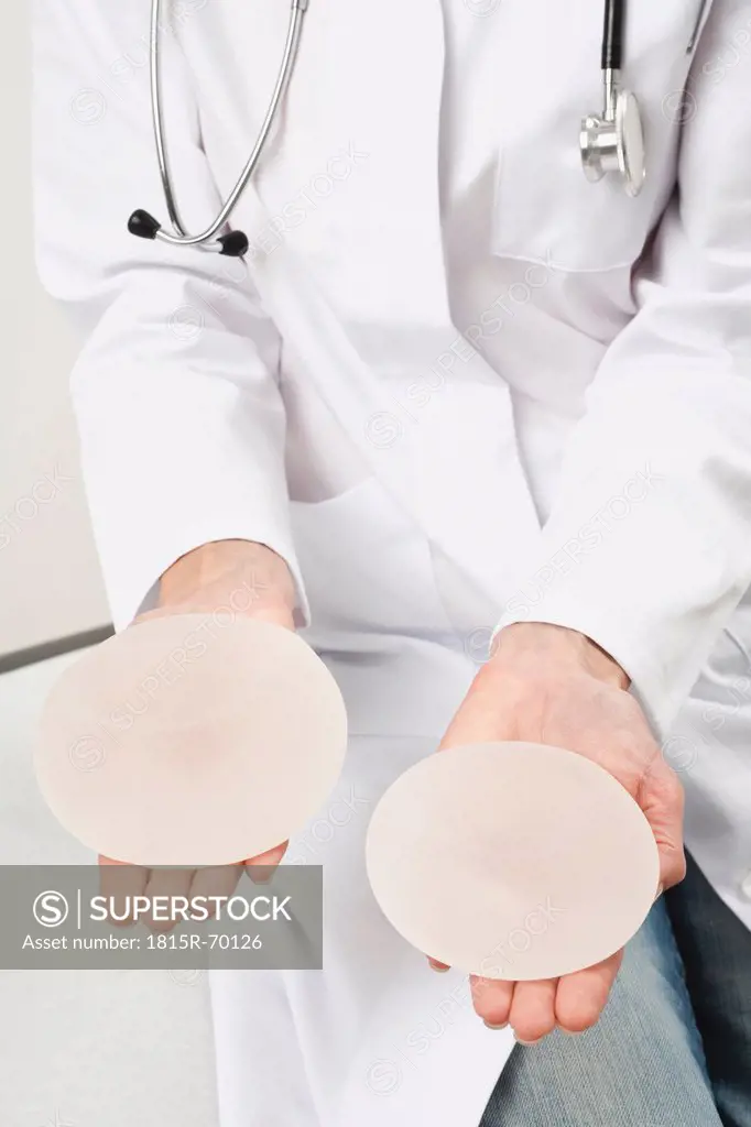 Germany, Munich, Doctor holding breast implant, close up