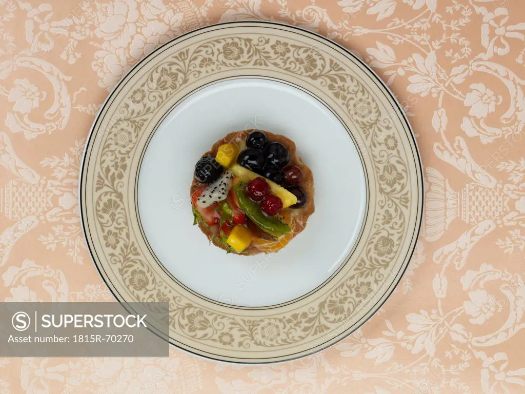 Fruitcake in plate against patterned background