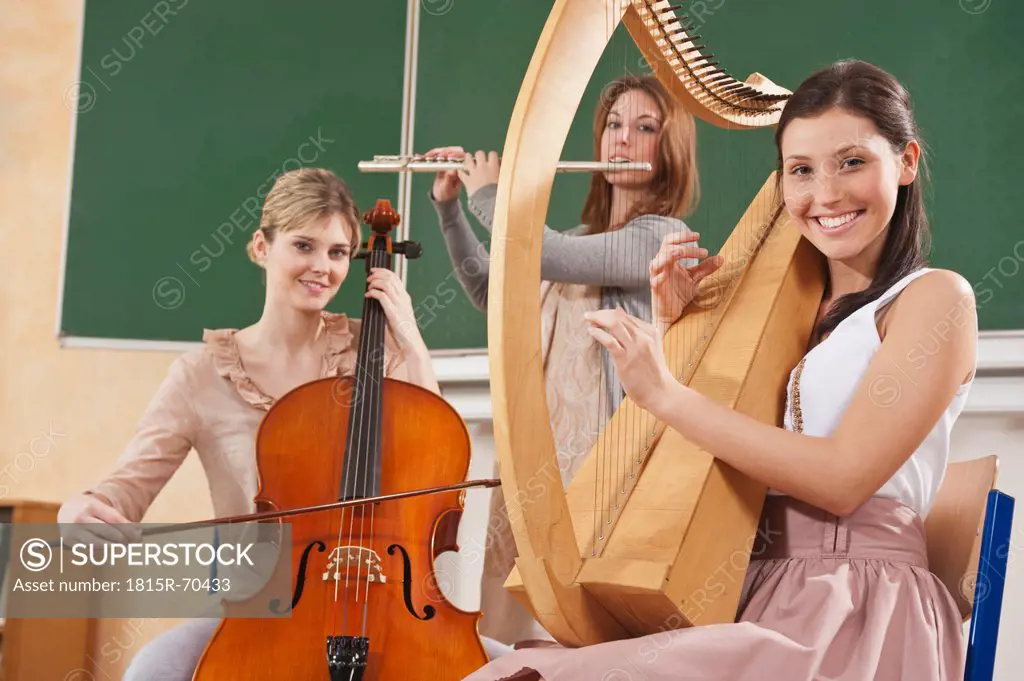 Germany, Emmering, Teenage girl and young women playing musical instruments