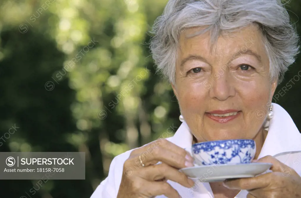 Senior woman holding cup of tea, close up