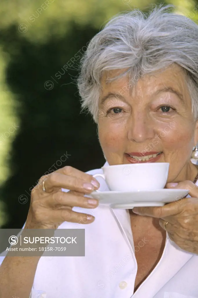 Senior woman drinking coffee, close up