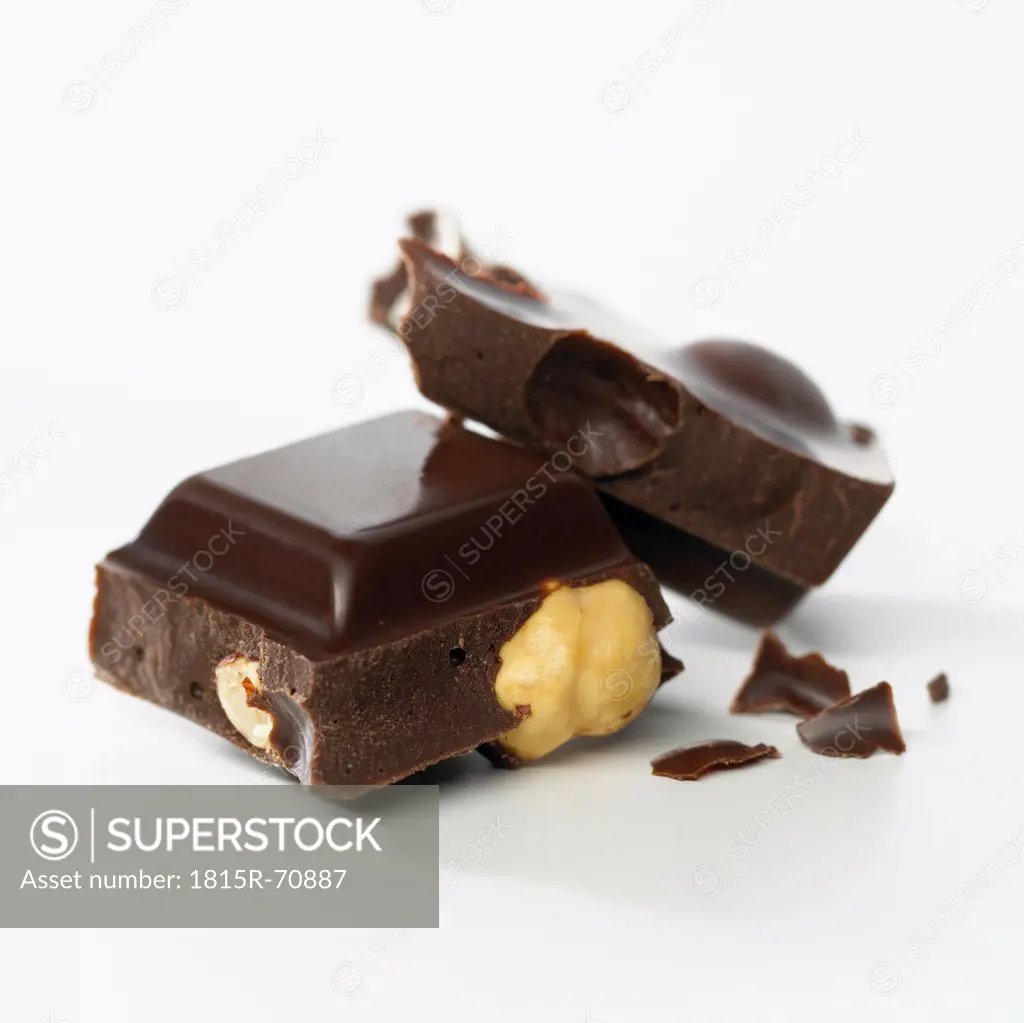 Chocolate with whole hazelnuts on white background