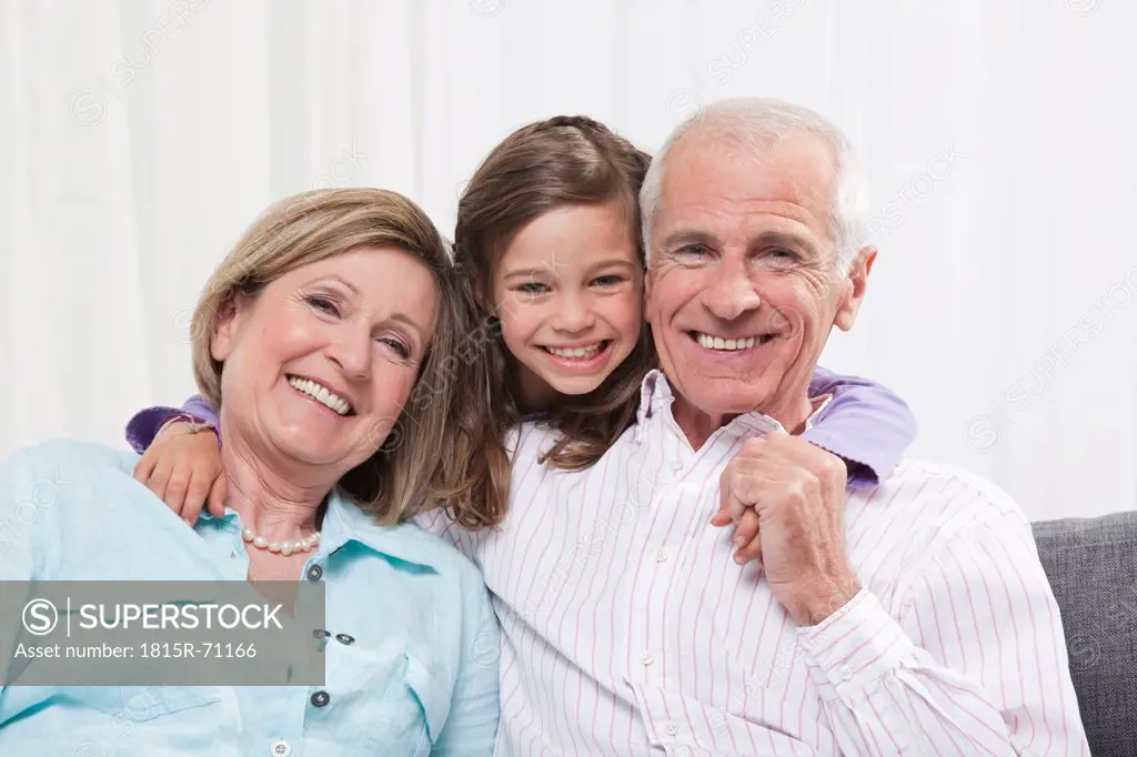 Granddaughter 6_7 arm around grandparents, smiling, portrait