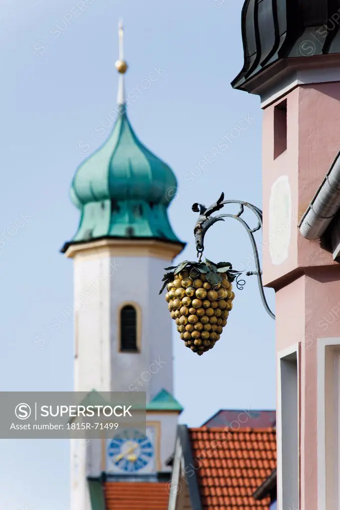 Germany, Bavaria, Murnau, View of inn sign with Maria_Hilf_Kirche in background