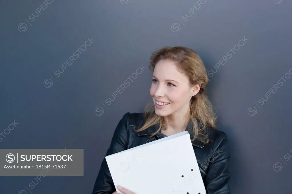 Germany, Leipzig, Young woman looking away, smiling
