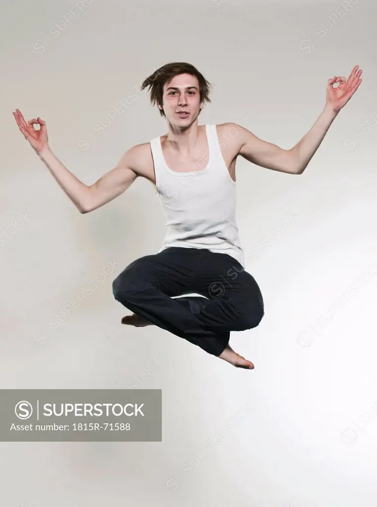 Man jumping with legs crossed and gesturing, portrait