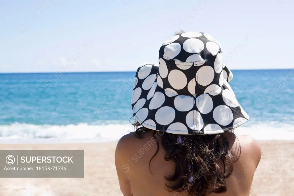 France, Corsica, Woman relaxing on beach, rear view