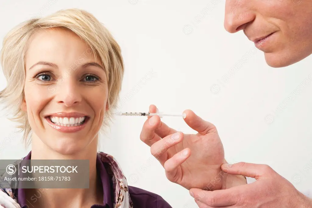 Germany, Munich, Doctor giving Botox treatment to woman