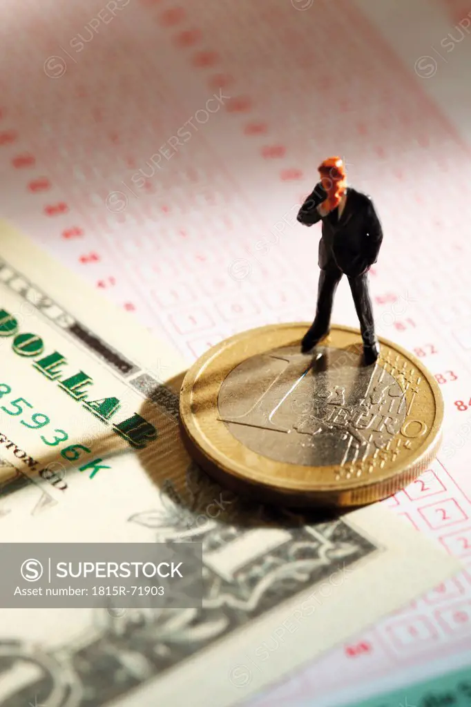 Manager figurine standing on betting slip with euro coin and 100 us dollar note