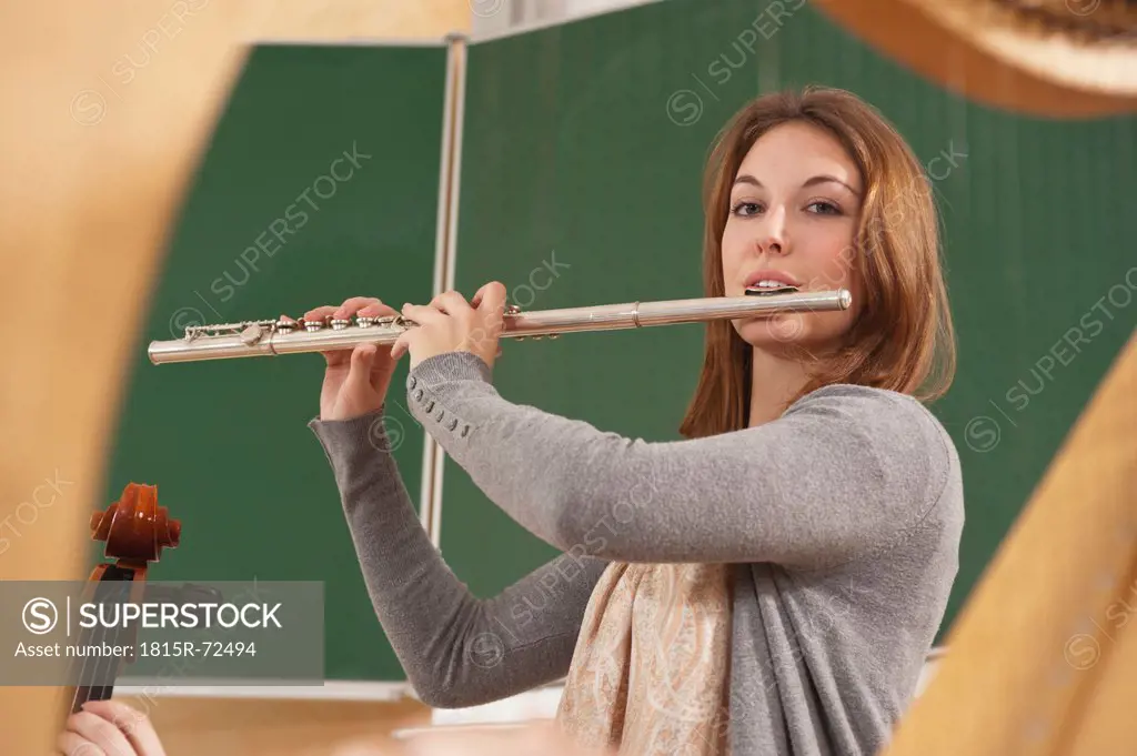 Germany, Emmering, Teenage girl blowing flute