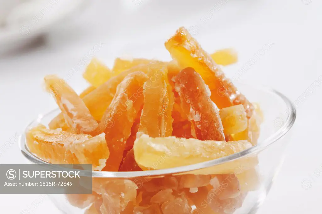 Candied ginger in bowl on white background