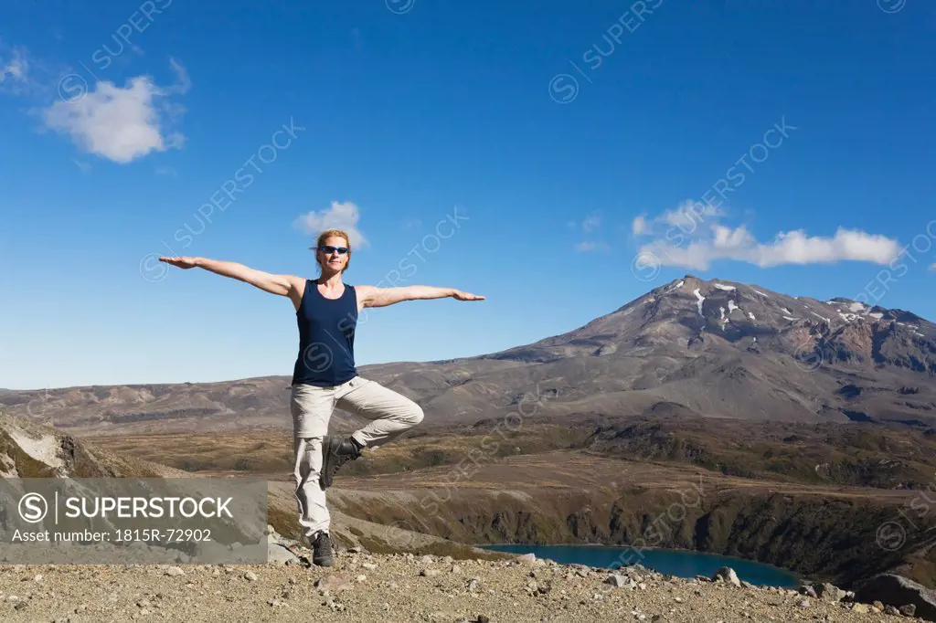 New Zealand, North Island, Woman doing exercise at tongariro national park with mount ruapehu in background