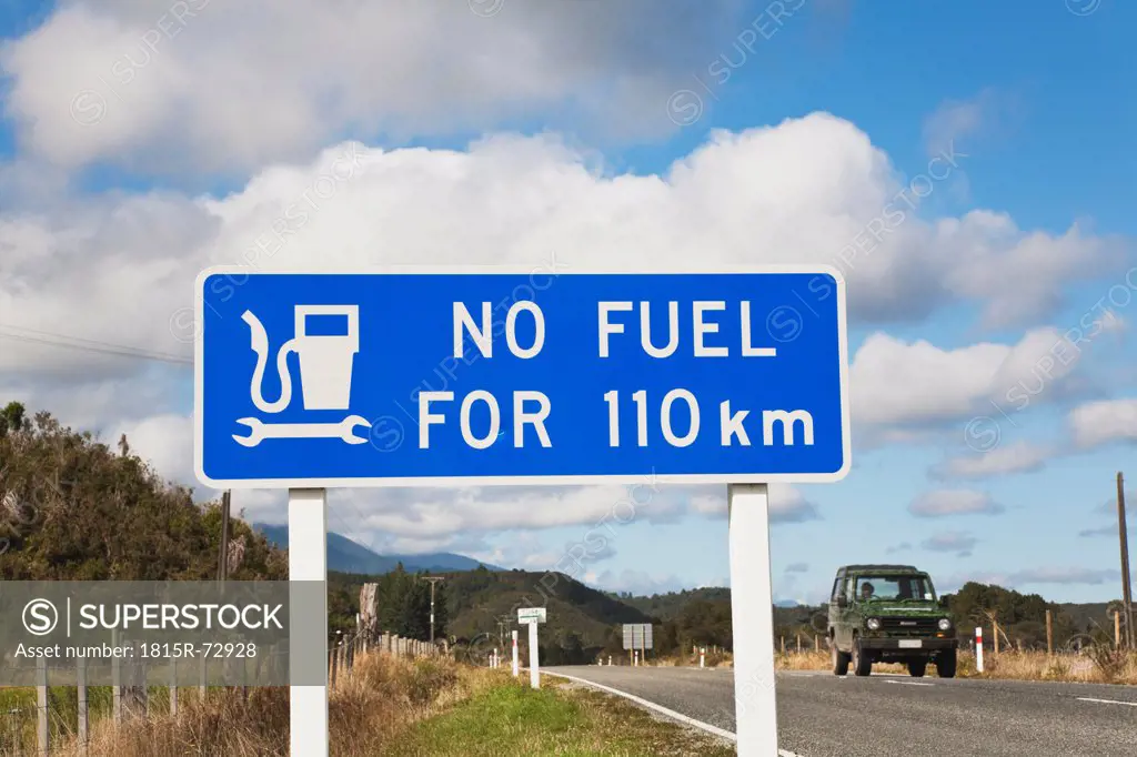 New Zealand, South Island, west coast, Information sign in close up with car on road in background