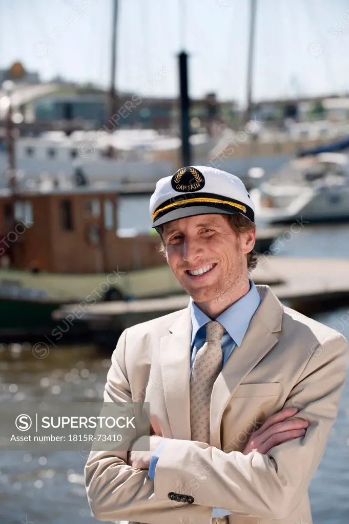 Germany, Hamburg, Man in suit with sailor cap, smiling