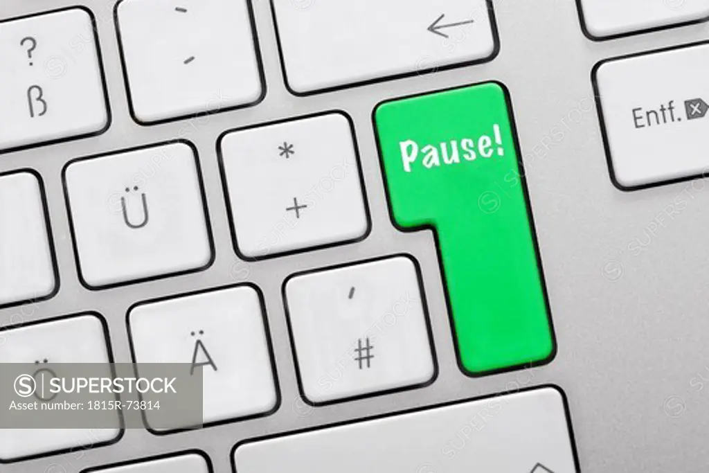 Illustration of keyboard having green key with pause sign, close up
