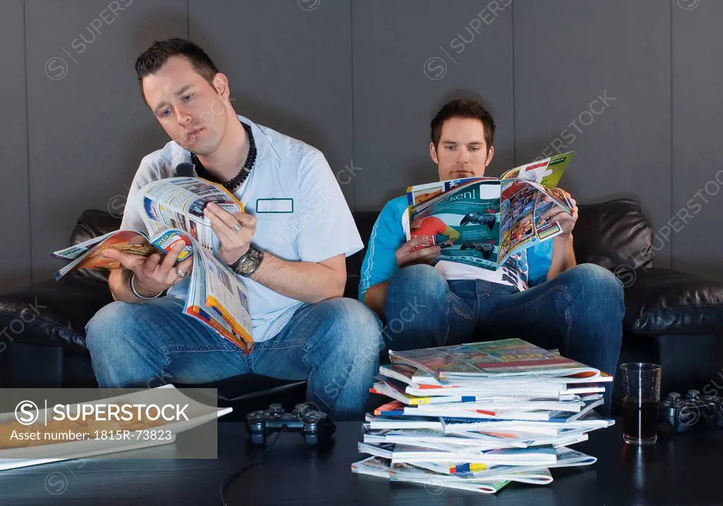 Men sitting on couch and reading magazines