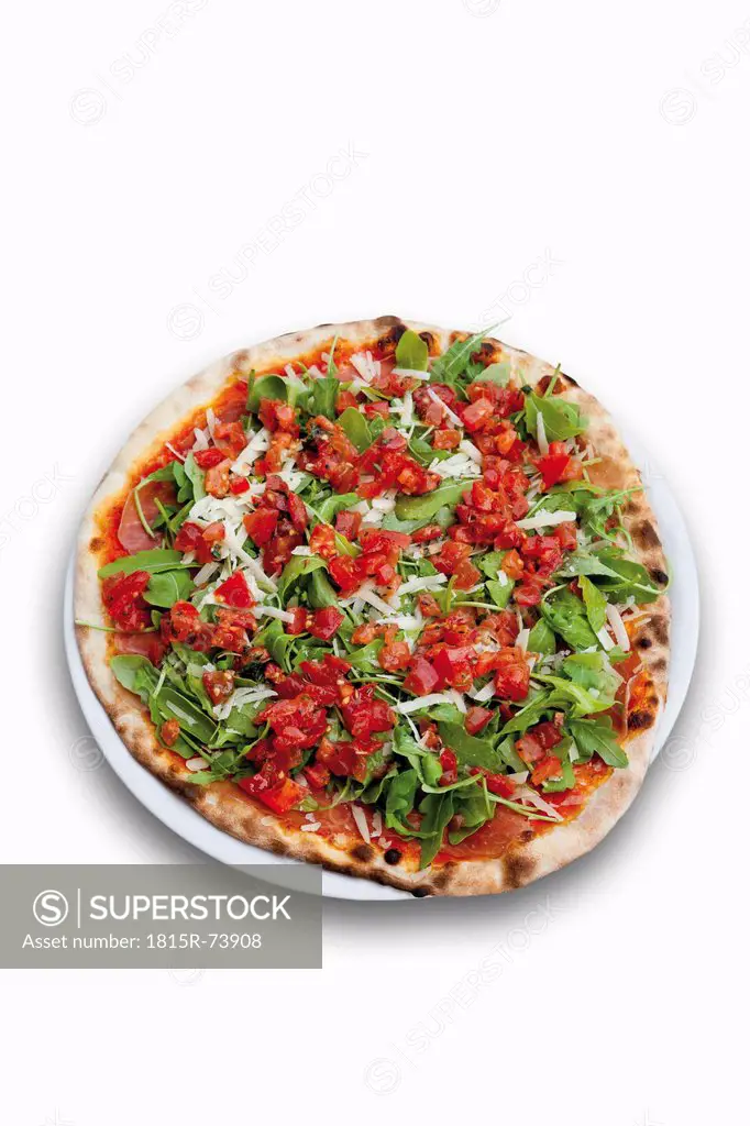 Pizza garnished with tomatoes, ham, rocket salad and parmesan