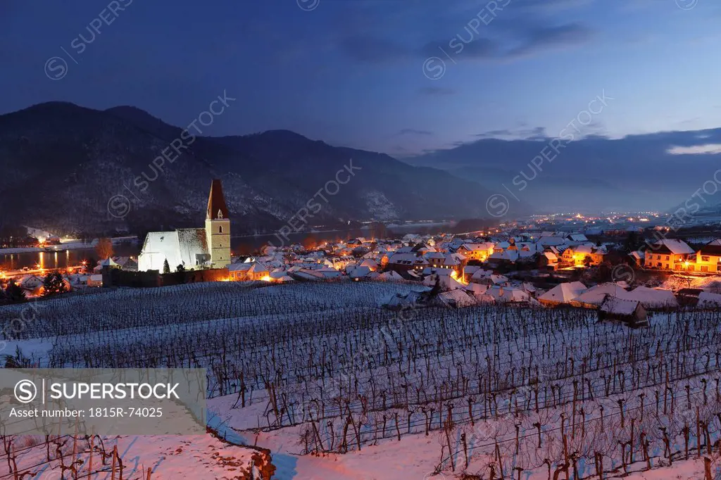 Austria, Lower Austria, Wachau, Waldviertel, View of snow covered vineyards with buildings at night