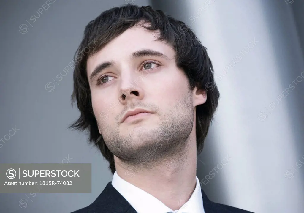 Germany, Disappointed young business man looking away