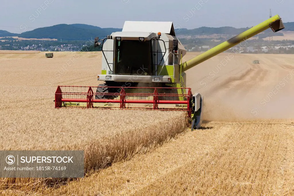 Germany, North Rhine_Westphalia, Combine harvester in field of wheat