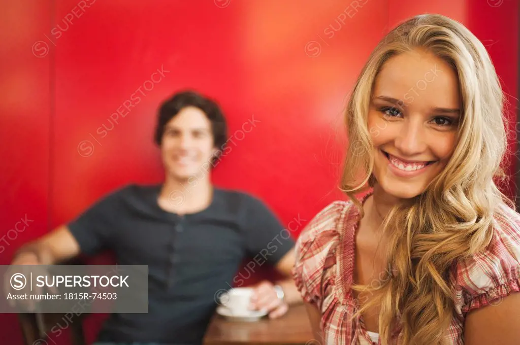 Germany, Munich, Teenage girl smiling with man in background