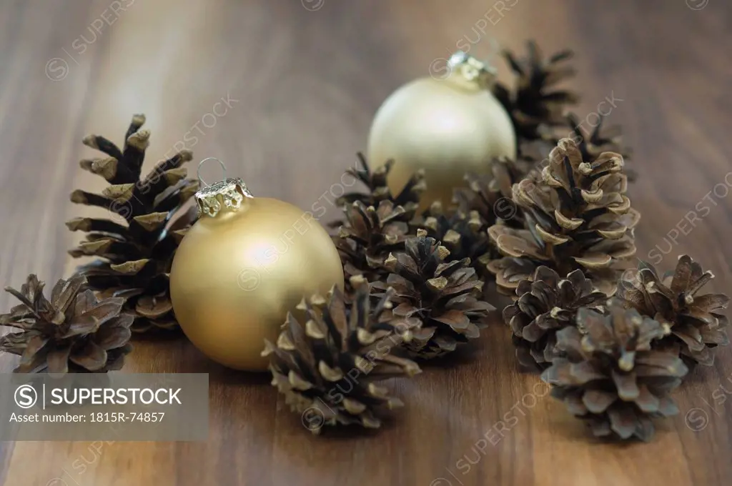 Close up of pine cones and golden christmas bauble