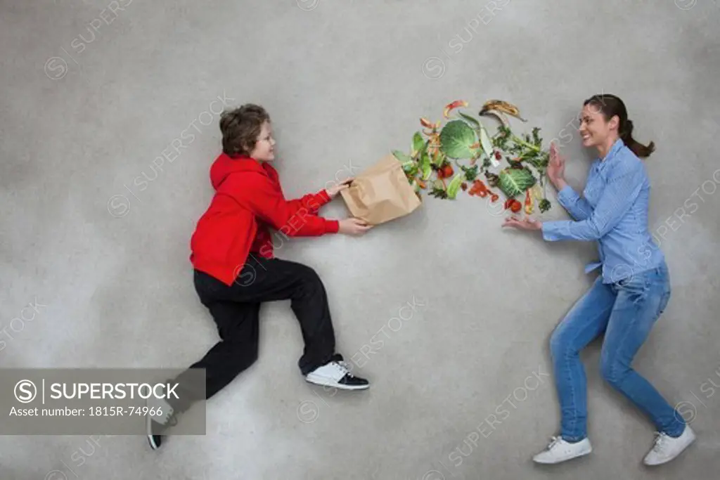 Woman and boy balancing vegetables