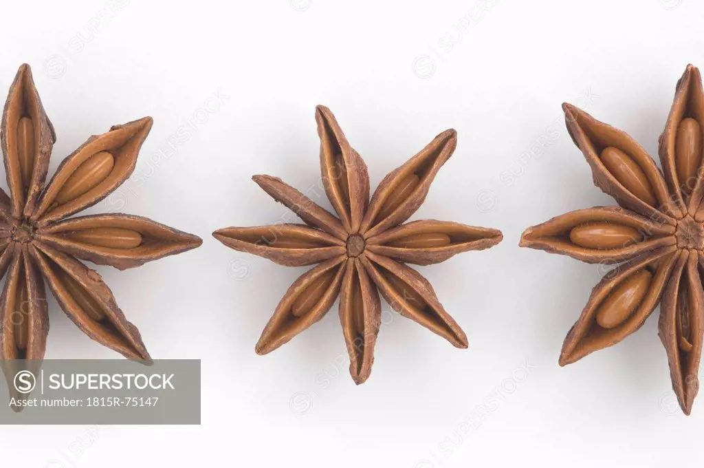Close up of three star anise against white background
