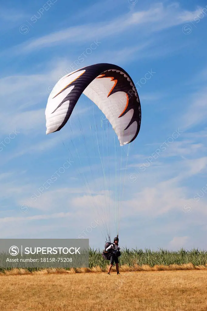 Germany, Moselle, Person parachuting landing on landscape