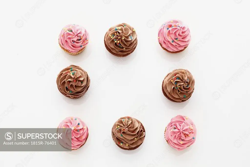 Strawberry and chocolate buttercream cupcakes against white background