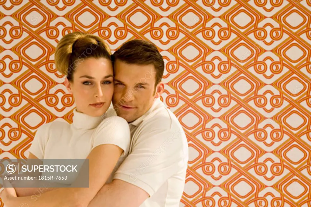 Young couple against wall paper, portrait