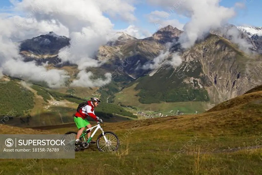 Italy, Livigno, View of woman riding mountain bike