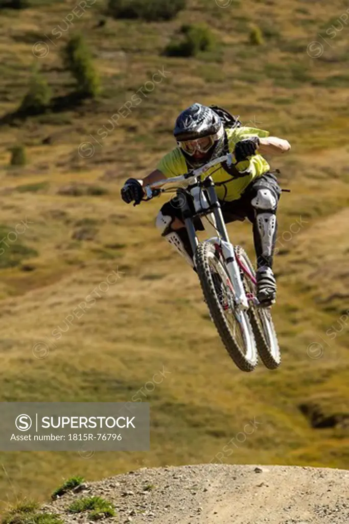 Italy, Livigno, View of man jumping with mountain bike