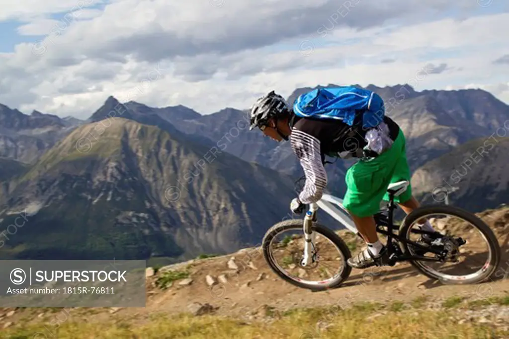 Italy, Livigno, View of man riding mountain bike downhill