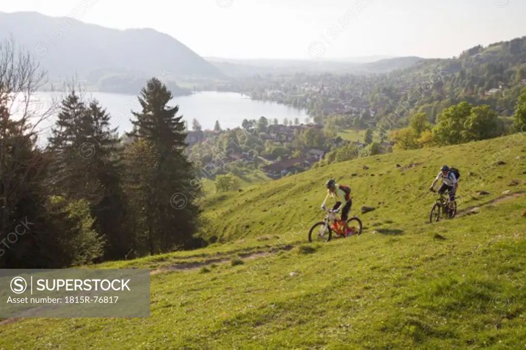 Germany, Bavaria, Schliersee, Man and woman moutainbiking on mountains